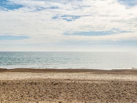 A beach with sand and sea under a cloudy sky at Windsurfer’s Rest - Hayling Island