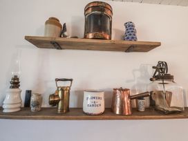 Two wooden shelves on a wall with vintage kitchen and decorative items at Briar Orchard Annex in Ammerham near Winsham