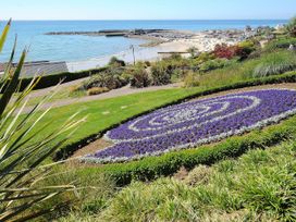 A coastal garden with flower beds overlooking a beach and harbor at Briar Orchard Annex in Ammerham near Winsham