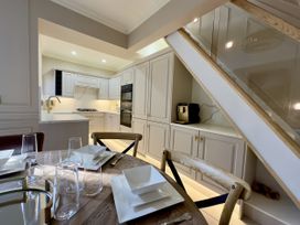 A kitchen and dining area with a wooden table set with plates and glassware at Ivy House in Conwy