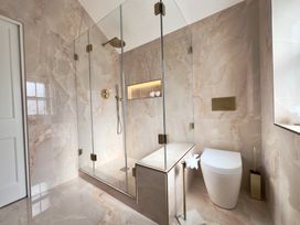 A bathroom with a glass shower enclosure and a white toilet at Ivy House in Conwy