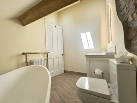 A bathroom with a bathtub toilet sink mirror and towel radiator at Ivy House in Conwy