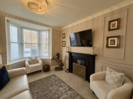 A living room with a television and fireplace at Ivy House in Conwy