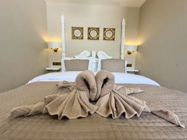 A bedroom with a towel swan on the bed at Ivy House in Conwy