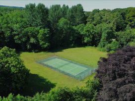 A tennis court surrounded by trees at Westward Park near Wigton