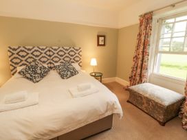 A bedroom with a bed and an ottoman at Westward Park in Westward near Wigton