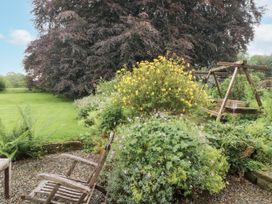 A garden with flowering plants and a wooden swing at Westward Park in Westward near Wigton