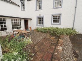 A courtyard with a table and chairs at Westward Park near Wigton