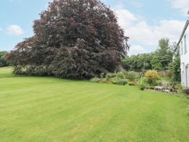 A garden with a large tree and seating area at Westward Park near Wigton