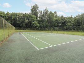 A tennis court surrounded by trees at Westward Park near Wigton