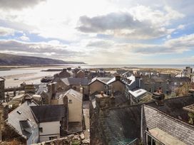 Rooftops of houses with a river sandbank and hills in the background at Top Cottage in Barmouth