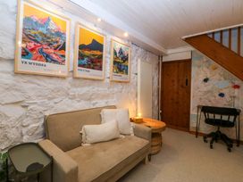 A snug with a sofa and posters on the wall at Waterfall Retreat in Blaenau Ffestiniog