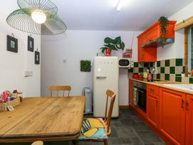 A kitchen with a table and refrigerator at Waterfall Retreat in Blaenau Ffestiniog