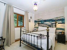 A bedroom with a bed and a nightstand at Waterfall Retreat in Blaenau Ffestiniog