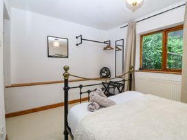 A bedroom with a bed and a clothes rail at Waterfall Retreat in Blaenau Ffestiniog
