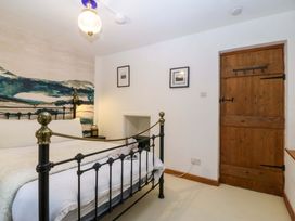 A bedroom with a bed and wooden door at Waterfall Retreat in Blaenau Ffestiniog