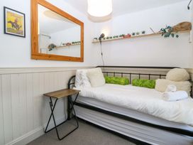 A bedroom with a bed, mirror, and table at Waterfall Retreat in Blaenau Ffestiniog