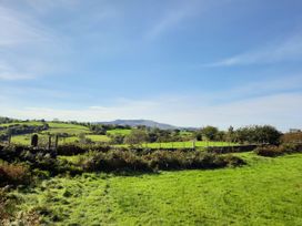 A landscape with grassy fields and a fence at Waterfall Retreat in Blaenau Ffestiniog