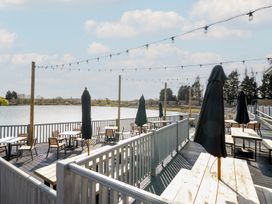 An outdoor seating area with tables and umbrellas at Ripples & Reeds - Billing Aquadrome Billing Aquadrome Holiday Park