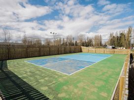 A tennis court with a surrounding fence at Ripples & Reeds - Billing Aquadrome