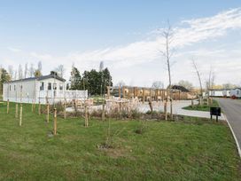 An outdoor area with a mobile home and seating near Duckling Den - Billing Aquadrome