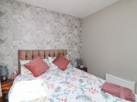 A bedroom with a bed and bedside table at Beech Lodge, Foulksmills, County Wexford