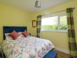 A bedroom with a bed and window at Beech Lodge, Foulksmills, County Wexford