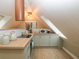 A kitchen with wooden countertops and cabinets under a sloped ceiling at Pheasants Rise Apartment in Ross-On-Wye