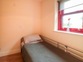 A bedroom with a bed and window at Shane's Cottage in Falcarragh, County Donegal