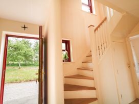 A hallway with a staircase and a front door at Shane's Cottage, Falcarragh, County Donegal