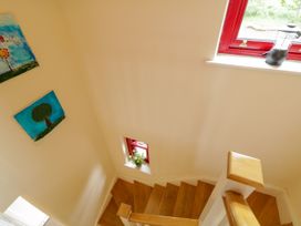 A staircase with paintings on the wall at Shane's Cottage, Falcarragh, County Donegal
