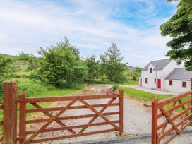 A house with a gate and gravel driveway at Shane's Cottage in Falcarragh, County Donegal