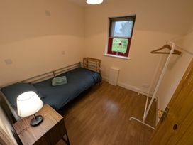 A bedroom with a bed and lamp at Shane's Cottage in Falcarragh, County Donegal