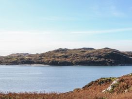A body of water with hills and vegetation in the background at Creag Mhor Lodge Back of Keppoch near Arisaig