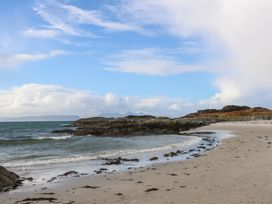 A sandy beach with seaweed and rocks by the ocean at Creag Mhor Lodge Back of Keppoch near Arisaig