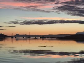 A body of water with boats anchored near the shore during sunset at Creag Mhor Lodge in Back of Keppoch near Arisaig