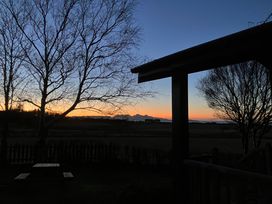 A sunset view with bare trees a picnic table and a fence at Creag Mhor Lodge Back of Keppoch near Arisaig