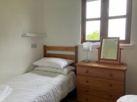 A bedroom with a single bed and wooden furniture at Island View Lodge Back of Keppoch near Arisaig