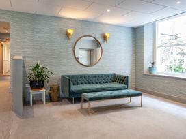 A lounge with a sofa, bench, mirror and plant at 43 The Salcombe, Salcombe