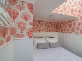 A bedroom with a bed and coathangers at 43 The Salcombe in Salcombe