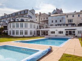 An outdoor area with a swimming pool and a building at 43 The Salcombe in Salcombe