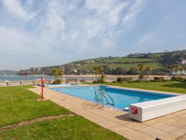 An outdoor swimming pool with a view of hills at 43 The Salcombe in Salcombe