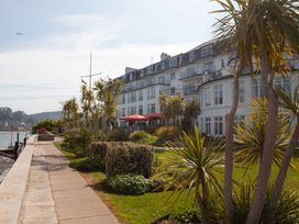 An outdoor area with a building and palm trees at 43 The Salcombe in Salcombe