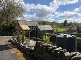 A garden with a wooden shed and water tank at Gwynfa in Ysbyty Ifan