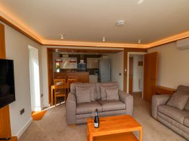 A living room with two sofas a wooden coffee table and a dining table in the background at Apartment 1 in Scarborough