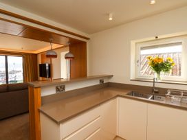 A kitchen with a countertop and sink next to a window with flowers at Apartment 1 in Scarborough