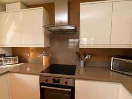 A kitchen with an oven stovetop range hood knife block toaster and microwave at Apartment 1 in Scarborough