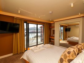 A bedroom with a bed and towels next to a window with a view of the waterfront at Apartment 1 Scarborough