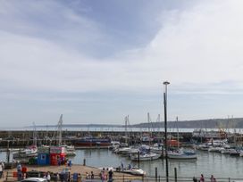 A harbor with boats docked and people walking near the water at Apartment 1 in Scarborough