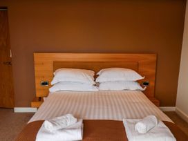 A bedroom with a double bed white pillows and towels on the bed at Apartment 2 in Scarborough